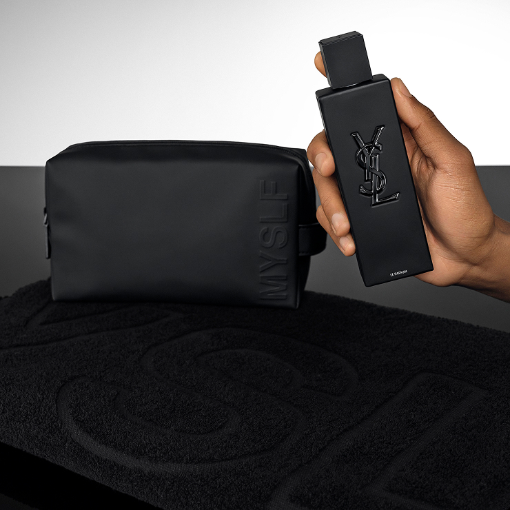 Hand holding the MYSLF Le Parfum bottle next to an exclusive black MYSLF pouch for gifting.