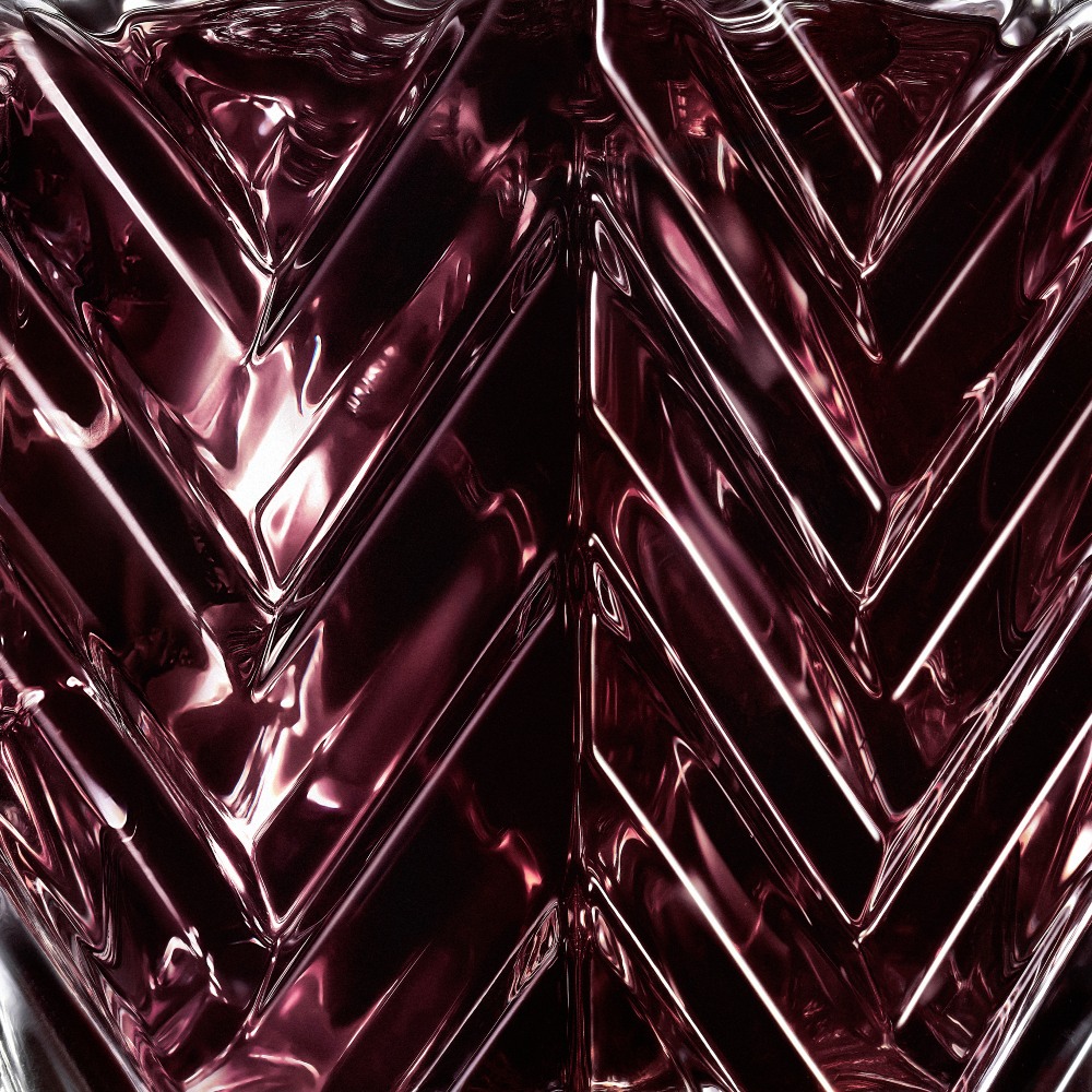 YSL LVDP Muse Extrait de Parfum 50ml bottle, close-up of deep red glass chevron texture
