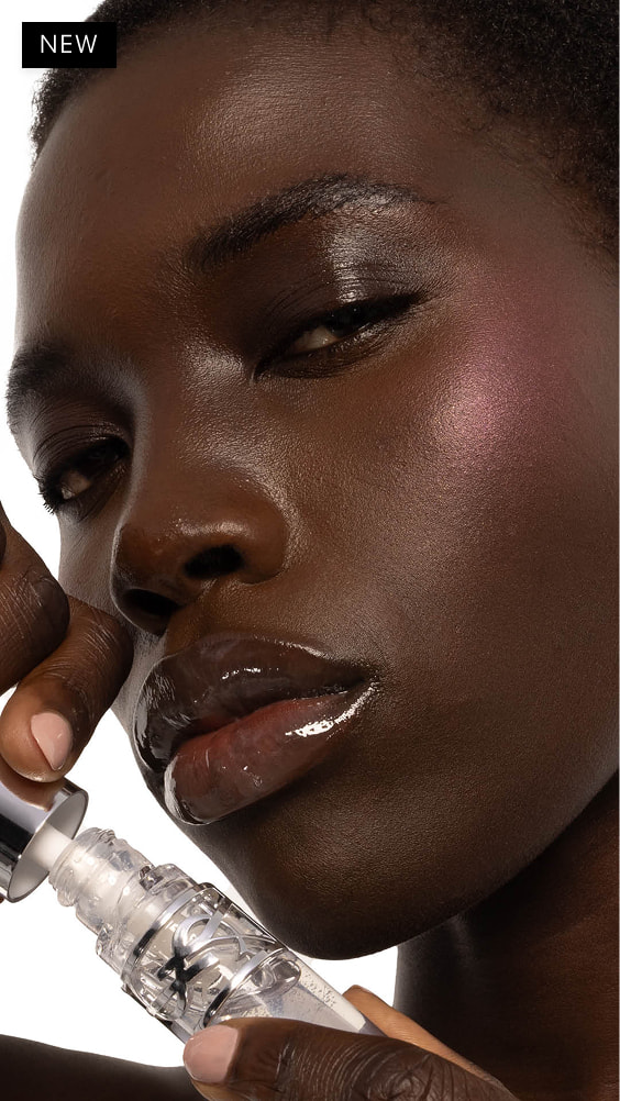 Nyaluak, deep-skinned, with YSL LOVESHINE Plumping Lip Oil Gloss in Shade 11 Radiant Glass, showcasing glossy lips.