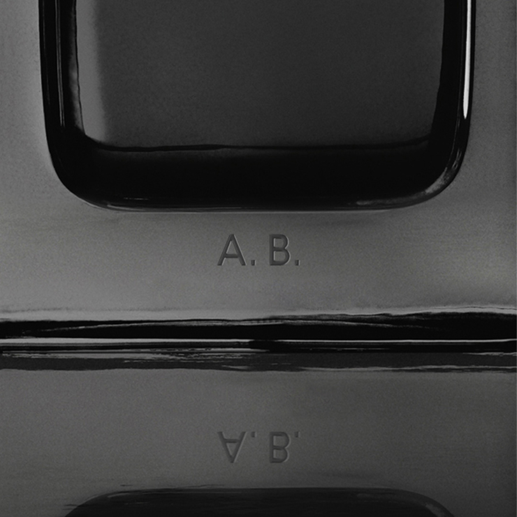 CClose-up of the MYSLF Eau de Parfum bottle base featuring personalized A.B. initials engraving.