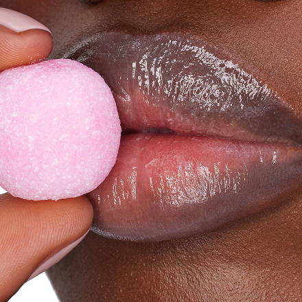 Close-up lips wearing YSL LOVESHINE CANDY GLAZE with glossy shine and pink candy.