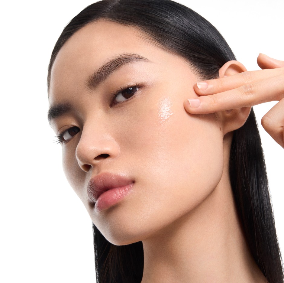 Fair-skinned model Mingma applying YSL Pure Shots Night Reboot Serum to her cheek for a glowing, hydrated look.