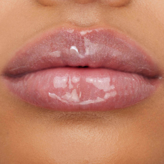 Close-up of fair-toned lips adorned with YSL LOVESHINE Plumping Gloss in Shade 1, highlighting its radiant, plumping effect.